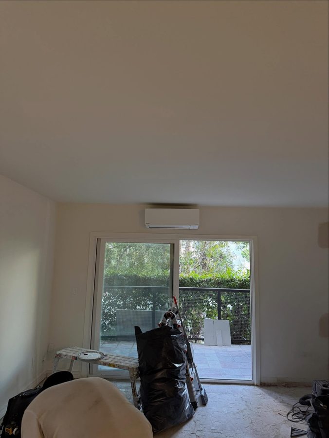 Finished Daikin mini-split head mounted above a sliding glass door in a condo